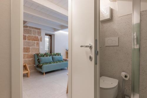 Una sala de estar con un sofá azul en una habitación. en MandorleOlio Versomare, en Polignano a Mare