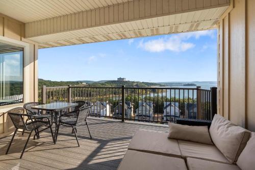 a screened in porch with a table and chairs on a balcony at The Lakeview Penthouse - 10ppl in Branson