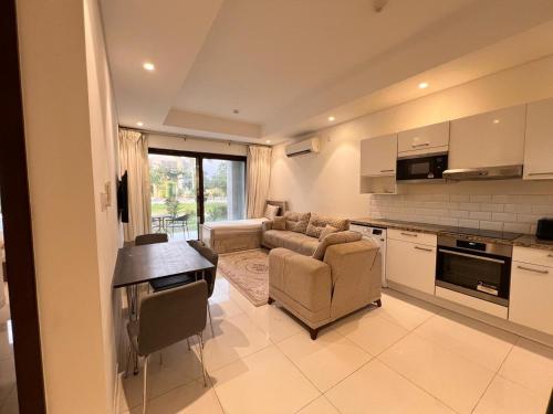 a kitchen and living room with a couch and a table at Royal Hawana Apartment salalah in Salalah