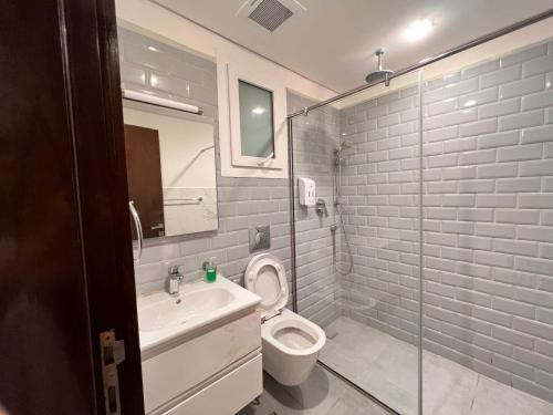 a bathroom with a toilet and a sink and a shower at Royal Hawana Apartment salalah in Salalah