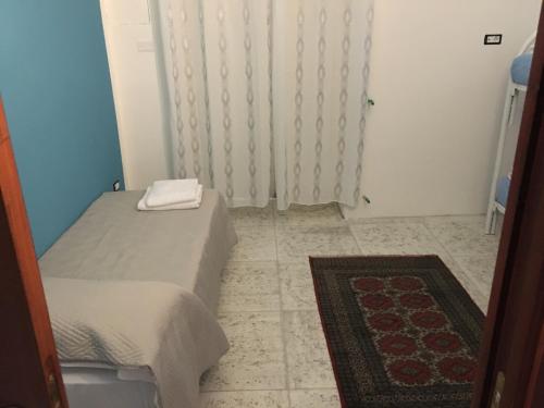 een kleine slaapkamer met een bed en een tapijt bij I due Grappoli in Boscotrecase