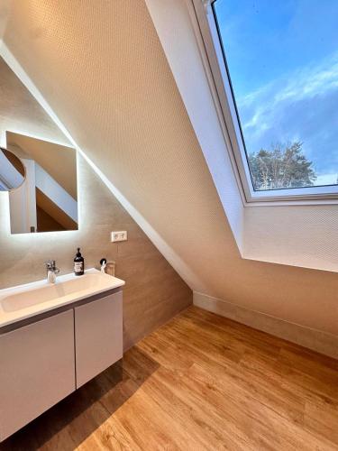 a bathroom with a sink and a window at Ferienhäuser Zinke in Krauschwitz
