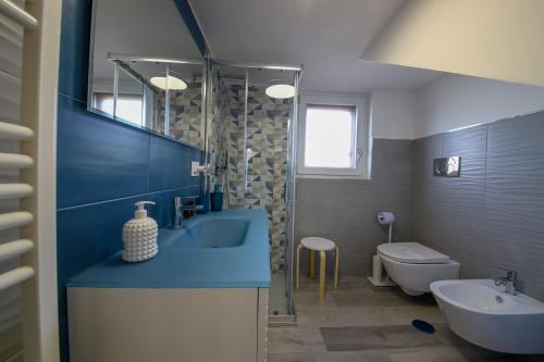 ein Badezimmer mit einem blauen Waschbecken und einer Toilette in der Unterkunft Villa Vera, accesso al mare, vista Castello, AC in Brindisi