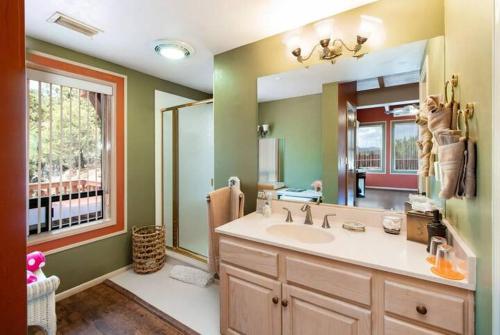 a bathroom with a sink and a large mirror at Sedona Views B&B and Luxury Creekside Cabins in Sedona
