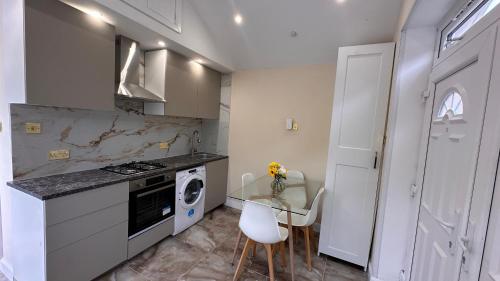 a kitchen with a table and a stove and a microwave at Modern Studio Luxe Heathrow London in New Bedfont