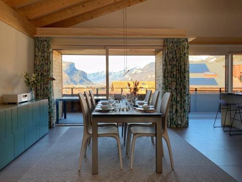 Un comedor con mesa y sillas y una gran ventana. en Mountain 4U, en Meiringen