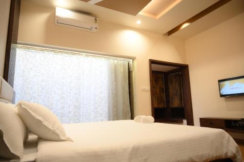 Ένα ή περισσότερα κρεβάτια σε δωμάτιο στο Shettar's Kusum Resort