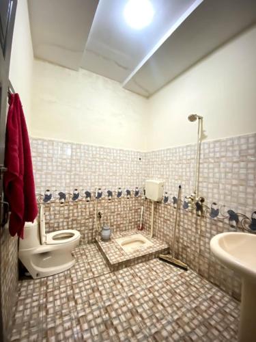 a bathroom with a toilet and a sink at Suites Inn in Faisalabad