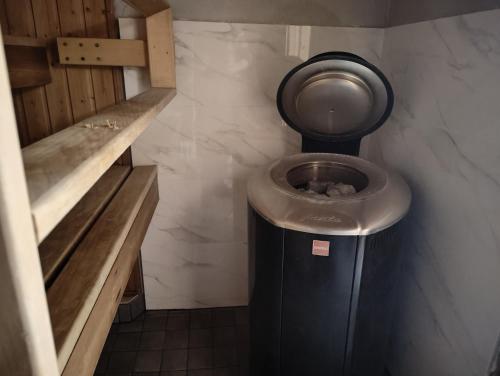 a bathroom with a toilet and a trash can at Arctic Aurora Villa with a Lappish Grill Hut - Northern Lights and Private Sledding Hill in the Backyard, in the Hometown of Santa Claus, Rovaniemi in Rovaniemi