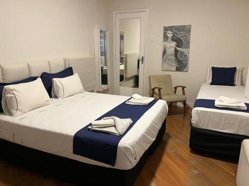 une chambre avec deux lits avec des serviettes dessus dans l'établissement Palais House, à São Vicente