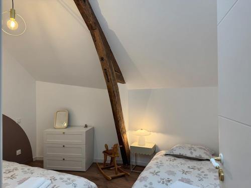 - une chambre avec deux lits et une commode avec un miroir dans l'établissement Le Grenier d'Antan - Near Mont-Saint-Michel, à Pontorson