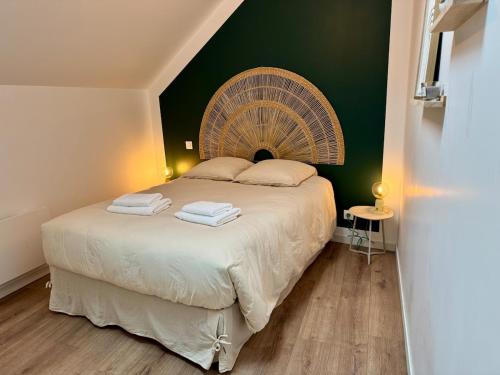 - une chambre avec un grand lit et un grand ventilateur dans l'établissement Le Grenier d'Antan - Near Mont-Saint-Michel, à Pontorson