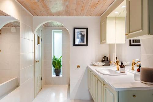 a white bathroom with a sink and a shower at Thatched country escape - Aarhus in Lystrup