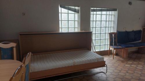 une chambre avec un lit, une table et des fenêtres dans l'établissement Apartment with a fireplace, à Saint-Wendel