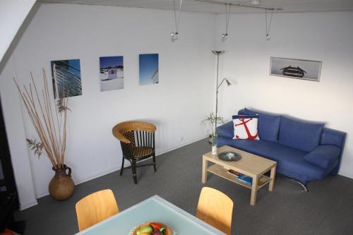 ein Wohnzimmer mit einem blauen Sofa und einem Tisch in der Unterkunft Wohnung in Gießelrade mit Großem Garten - b48578 in Ahrensbök