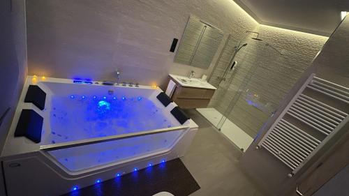 La salle de bains est pourvue d'une grande baignoire avec des lumières bleues. dans l'établissement La Era Rooms, à Lario