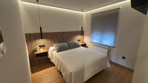 une chambre avec un lit blanc et une fenêtre dans l'établissement La Era Rooms, à Lario