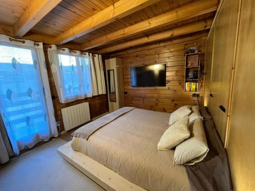 ein Schlafzimmer mit einem Bett und einem Flachbildfernseher in der Unterkunft Exclusiva Cabaña en Incles - Vistas al Valle & Pistas de Ski Grandvalira - Free Parking in Canillo