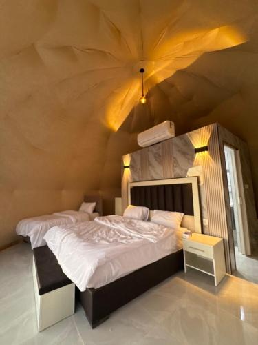 a bedroom with a large bed and a ceiling at SELEN RUM LUXURY CAMP & Jeep Tours in Wadi Rum