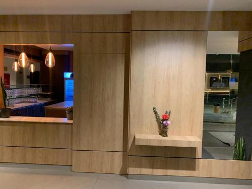 a vase of flowers sitting on a counter in a restaurant at شقق نازلين للشقق المخدومة in Al Bahadah
