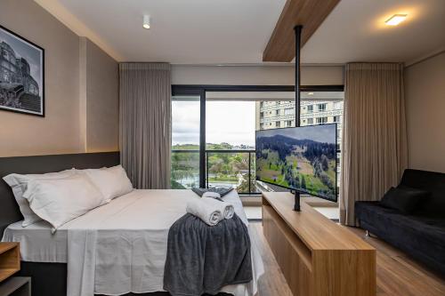 a bedroom with a bed and a large window at My Place in Curitiba