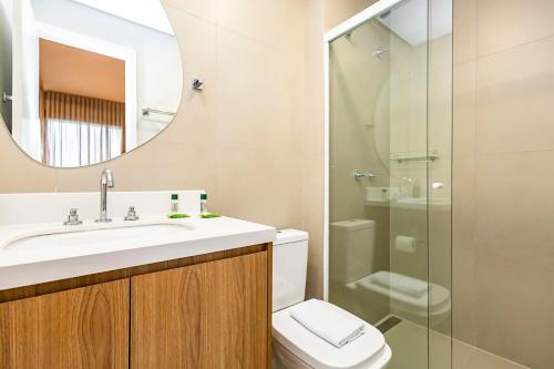 a bathroom with a sink and a toilet and a mirror at My Place in Curitiba
