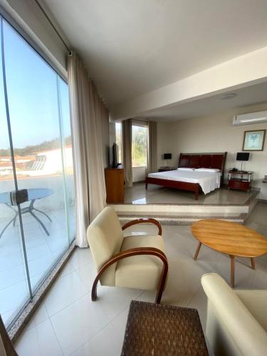 a bedroom with a bed and a table and a couch at San Fernando Hotel in São Luís