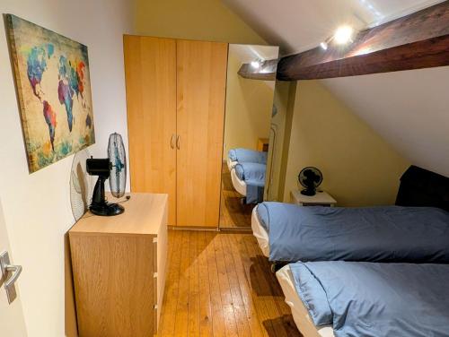 a attic bedroom with two beds and a cabinet at Duplex 3BR apartment near supermarkets & metro in Brussels