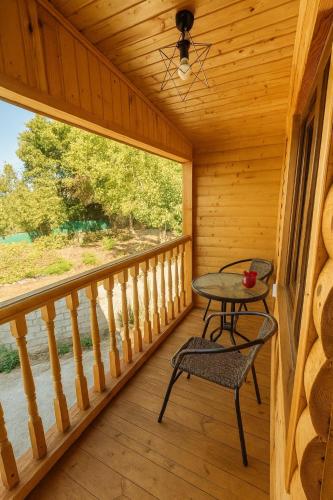a porch with a table and chair in a cabin at Zghapari Wooden Mountain Lodge in Aspindza