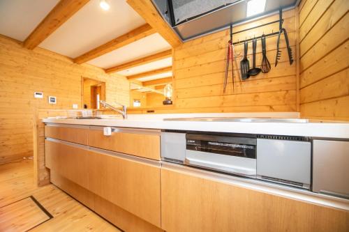 a kitchen with wooden walls and a stove top oven at Ａｗａｊｉ Ｓｅａｖｉｅｗ Ｒｅｓｏｒｔ ｉｎ Ｎｏｊｉｍａ - Vacation STAY 81998v in Kusumoto