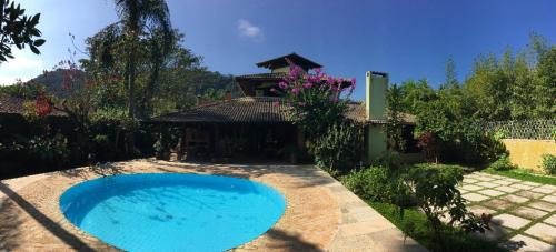 ein großer blauer Pool im Hof in der Unterkunft Casa da Jataí - Piscina e Pomar - Barra do Sahy in São Sebastião