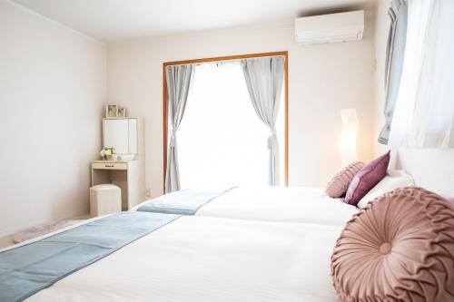 ein Schlafzimmer mit einem großen weißen Bett mit einem Fenster in der Unterkunft Kuwana - House - Vacation STAY 82016v in Genroku