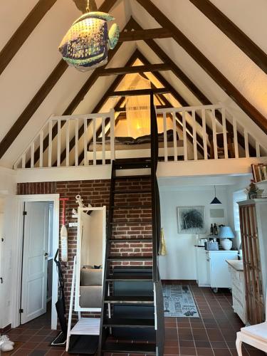 ein Raum mit einer Wendeltreppe und einer Decke in der Unterkunft Hyggelig am Deich in Ockholm