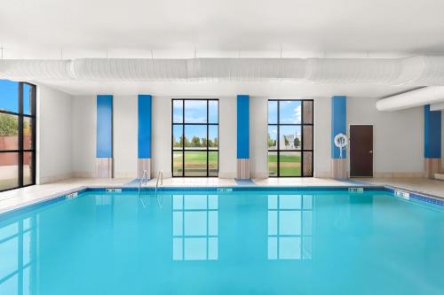 a pool with blue water in a building with windows at Four Points by Sheraton Oklahoma City Quail Springs in Oklahoma City