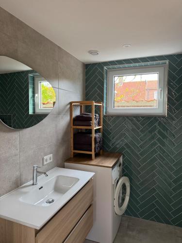 a bathroom with a sink and a washing machine at Casa Del Faro in Westkapelle