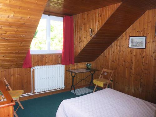 Schlafzimmer mit einem Bett, einem Fenster und einem Tisch in der Unterkunft Le Buisson in Montlouis-sur-Loire