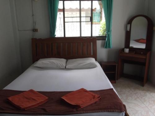 a bedroom with a bed with two towels on it at Palm Point Village in Mae Nam