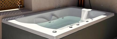 a white bath tub with a sink in a bathroom at Athina's Cozy Guest House in Kamisianá