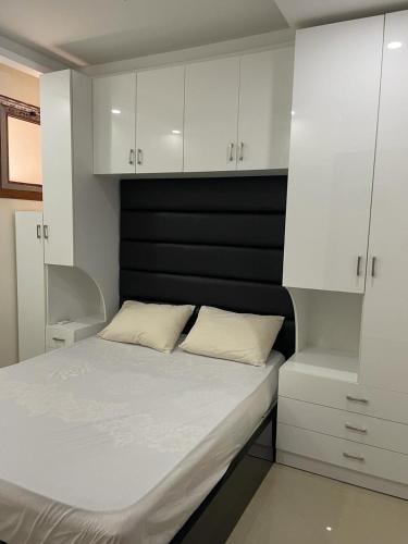 1 dormitorio con 1 cama blanca y armarios blancos en One bedroom apartment in SHARM HILLS, Sharm-El-Sheikh, en Sharm El Sheikh