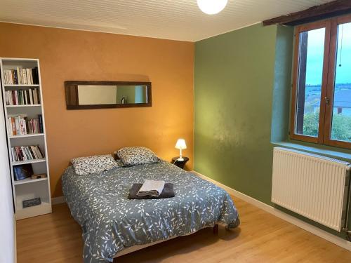 een slaapkamer met een bed en een boekenplank bij 70m2 dans une ferme en Isère in Le Pont-de-Beauvoisin