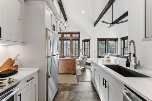 布雷肯里奇Aurum Condo - 1 BR with Mtn Views, Steps from Main St的配有白色橱柜和不锈钢冰箱的厨房