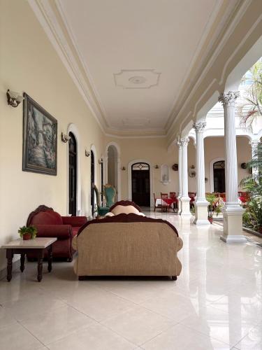 a bedroom with a bed and a couch in a room at Gran Real Yucatan in Mérida