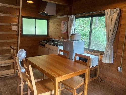 une salle à manger avec une table en bois et une cuisine dans l'établissement Sky Lodge Gingamura - Vacation STAY 84483v, à Shironita