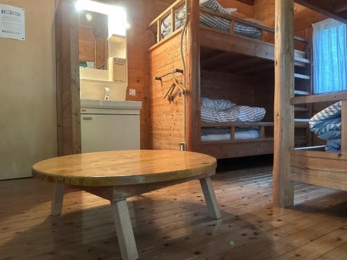 une chambre avec une table en bois et des lits superposés dans l'établissement Sky Lodge Gingamura - Vacation STAY 84488v, à Shironita