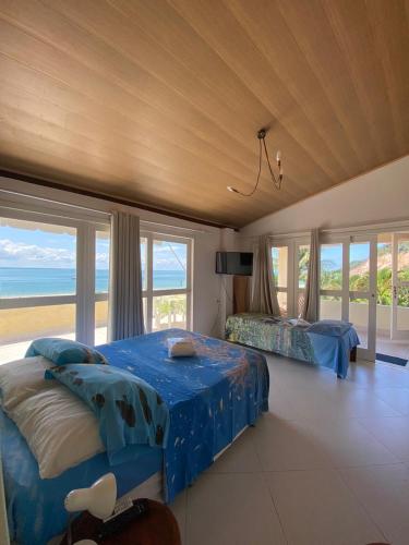a bedroom with two beds and a view of the ocean at Pousada Chic N Choc in Morro de São Paulo