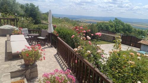 a balcony with a bunch of flowers and an umbrella at къща за гости villa Jurta in Avren