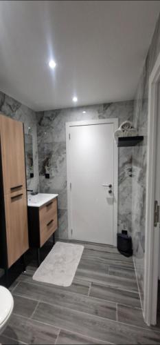 a bathroom with a white door and a sink at Chez fina in Ath