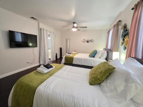 ein Hotelzimmer mit zwei Betten und einem Flachbildfernseher in der Unterkunft Newly Listed Family Friendly Fontana House in Fontana