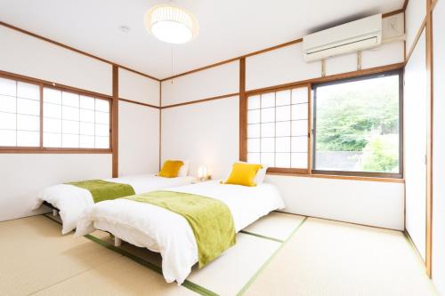 2 Betten in einem Zimmer mit Fenstern in der Unterkunft Yokkaichi - House - Vacation STAY 85333v in Kawashima