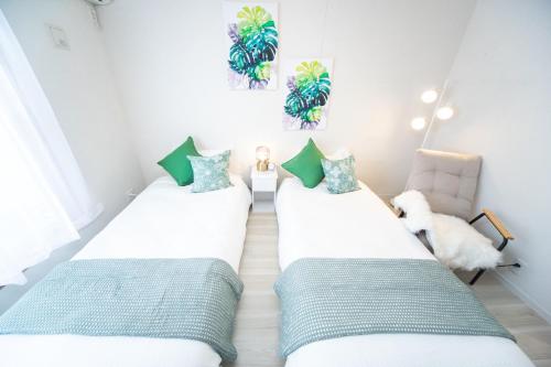 2 Einzelbetten in einem Zimmer mit einem Stuhl in der Unterkunft Kuwana - House - Vacation STAY 85367v in Maegasu-shinden